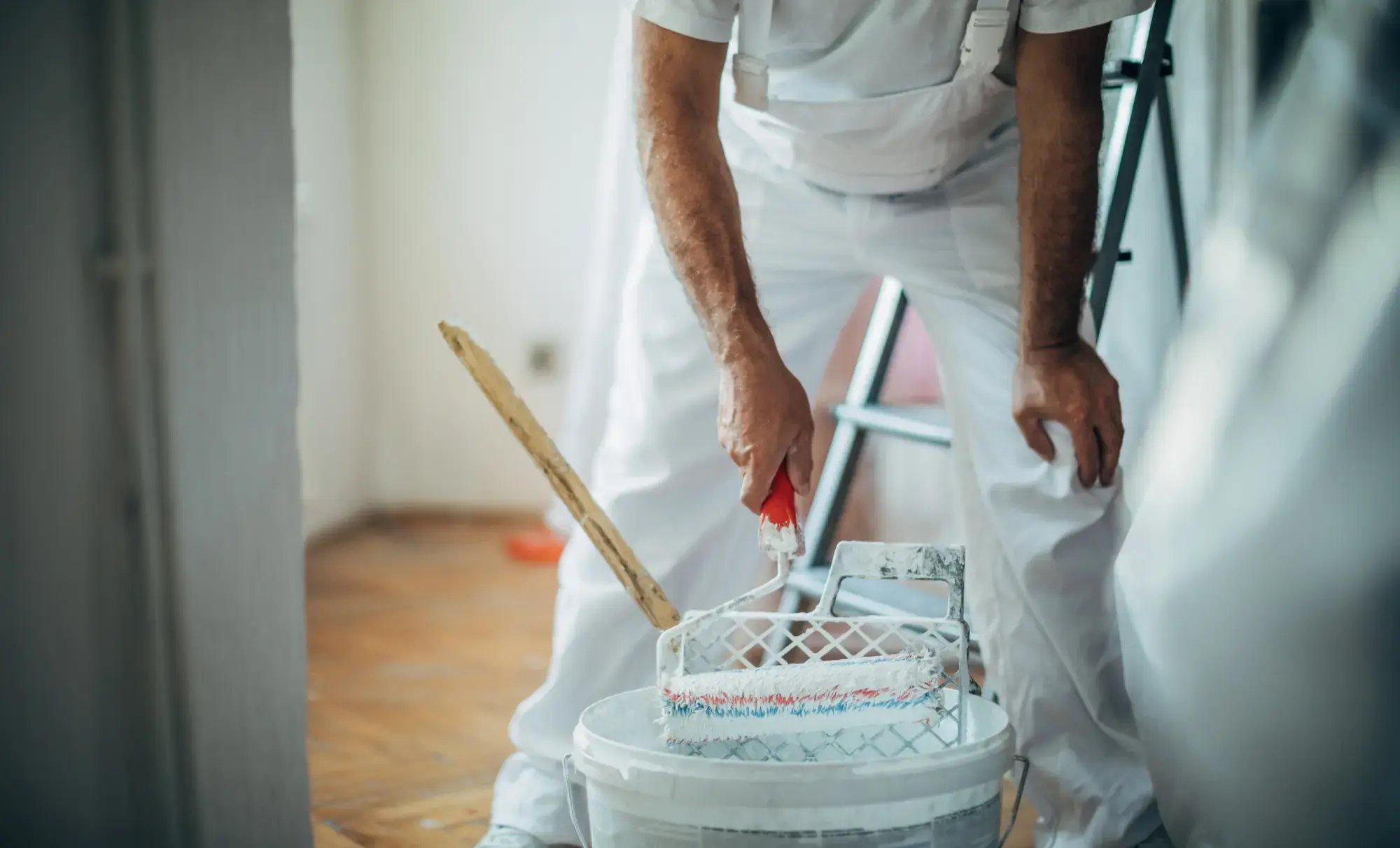 Målare doppar roller i vit färg och tänker på bokföring och fakturering