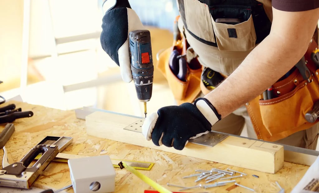 Snickare använder skruvdragare på arbetsbänk och tänker på ROT- och RUT-avdrag